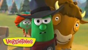 Green vegetable character wearing a black hat, with a bronze-brown animal beside him, in a VeggieTales scene with a yellow VeggieTales logo bottom left.