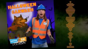 Promotional image for Halloween Carwash featuring a man in an orange safety vest and blue hard hat posing in front of a purple poster with a monster truck illustration and the title 'HALLOWEEN CARWASH'.
