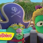 Two green VeggieTales characters in a boat at a tropical beach; one wears a pirate hat and yellow glasses, the other looks surprised; VeggieTales logo visible on the left.