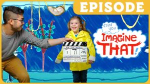 Man and a smiling young girl pose with a clapperboard in front of a bright, illustrated backdrop that says 'Imagine That!' Episode banner is at the top right.