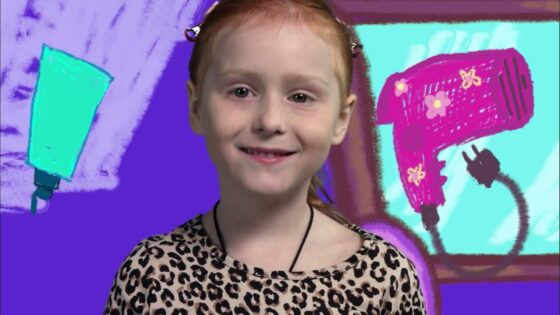 Smiling young girl with red hair wearing a leopard-print shirt, posed in front of a bright, cartoon-style purple background.