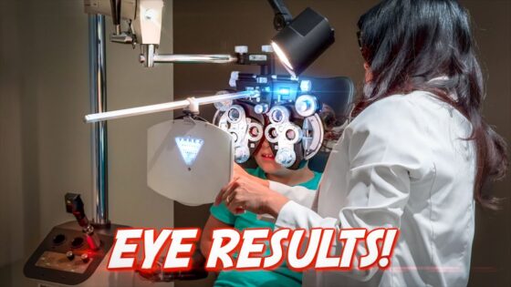 Ophthalmologist adjusting a slit lamp to examine a patient's eyes during an eye exam, in a clinical setting with medical equipment visible.