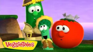 Three VeggieTales characters—a cucumber, broccoli, and tomato—stand on a grassy stage with a purple sky. VeggieTales logo is bottom left.