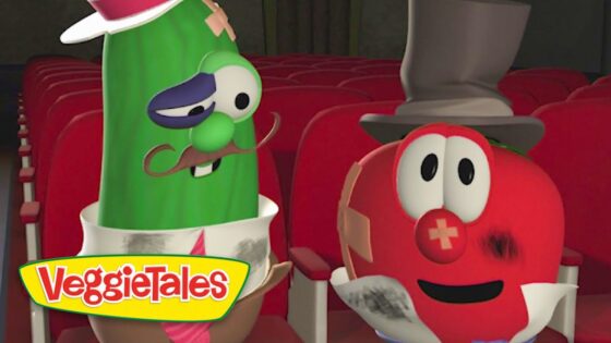 Green cucumber with a mustache and top hat sits beside a red tomato with a hat in a theater row, VeggieTales logo visible in front.
