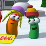 Three colorful VeggieTales characters stand on snow, smiling and chatting in a wintry scene with a logo in the corner.