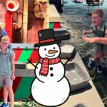 Man in a cowboy hat pose with three children at a colorful indoor play area; cartoon snowman overlays the foreground.