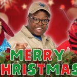 Person in safari-style outfit with two puppets, 'Merry Christmas' text in front, festive red background with pine garland and pinecones.