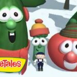 Three VeggieTales characters—a tall green cucumber, a red tomato, and a small green bean—wear winter hats in a snowy landscape, with a VeggieTales logo in the corner.