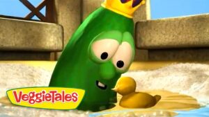 Green VeggieTales character wearing a crown leans toward a small yellow duckling in shallow water, with a cheerful expression.