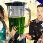 Two people in party outfits react with surprise beside a large blender full of green juice, with confetti around them and a celebratory vibe (exclusive thumbnail).