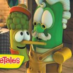 Two VeggieTales characters, a corn cob and a green vegetable with a mustache and glasses, kiss in a rustic kitchen, with the VeggieTales logo in the corner.