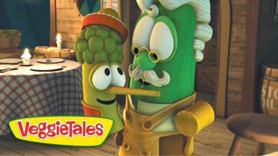 Two VeggieTales characters, a corn cob and a green vegetable with a mustache and glasses, kiss in a rustic kitchen, with the VeggieTales logo in the corner.