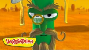 Green VeggieTales character with a monocle and long beige beard, standing in a yellow desert, VeggieTales logo in the corner.