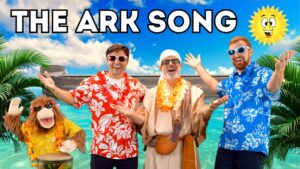 Four people (including a costumed monkey) in Hawaiian shirts strike poses by turquoise water, with 'THE ARK SONG' title overhead at a sunny beach.