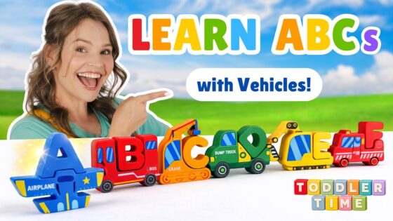 Smiling woman pointing at a row of colorful toy vehicles forming the ABCs in a bright outdoor scene, for a kids' learning video.