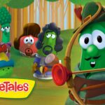 Green veggie archer aiming a bow in a forest, VeggieTales logo at bottom left, group of humanoid vegetables watching.