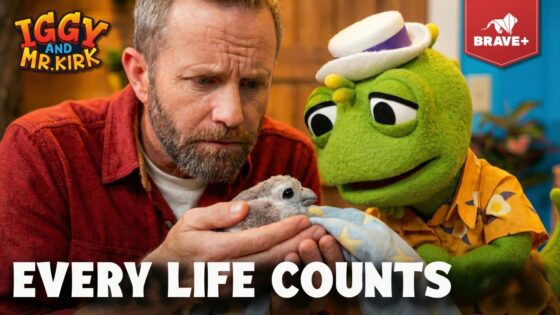 Bearded man holding a small chick wrapped in a blanket, while a green puppet gazes on; bold 'EVERY LIFE COUNTS' text overlays with Iggy and Mr. Kirk branding and Brave+ logo.
