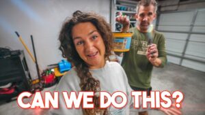 Smiling woman with curly hair and a man in a green shirt hold a yellow bucket toward the camera in a garage, with the bold caption 'CAN WE DO THIS?'