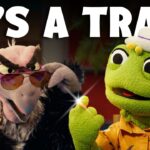 Two puppets from a kids' show in a dramatic scene: a green frog in a hat and orange shirt, and a feathery villain wearing sunglasses, with the text 'It's a trap!'